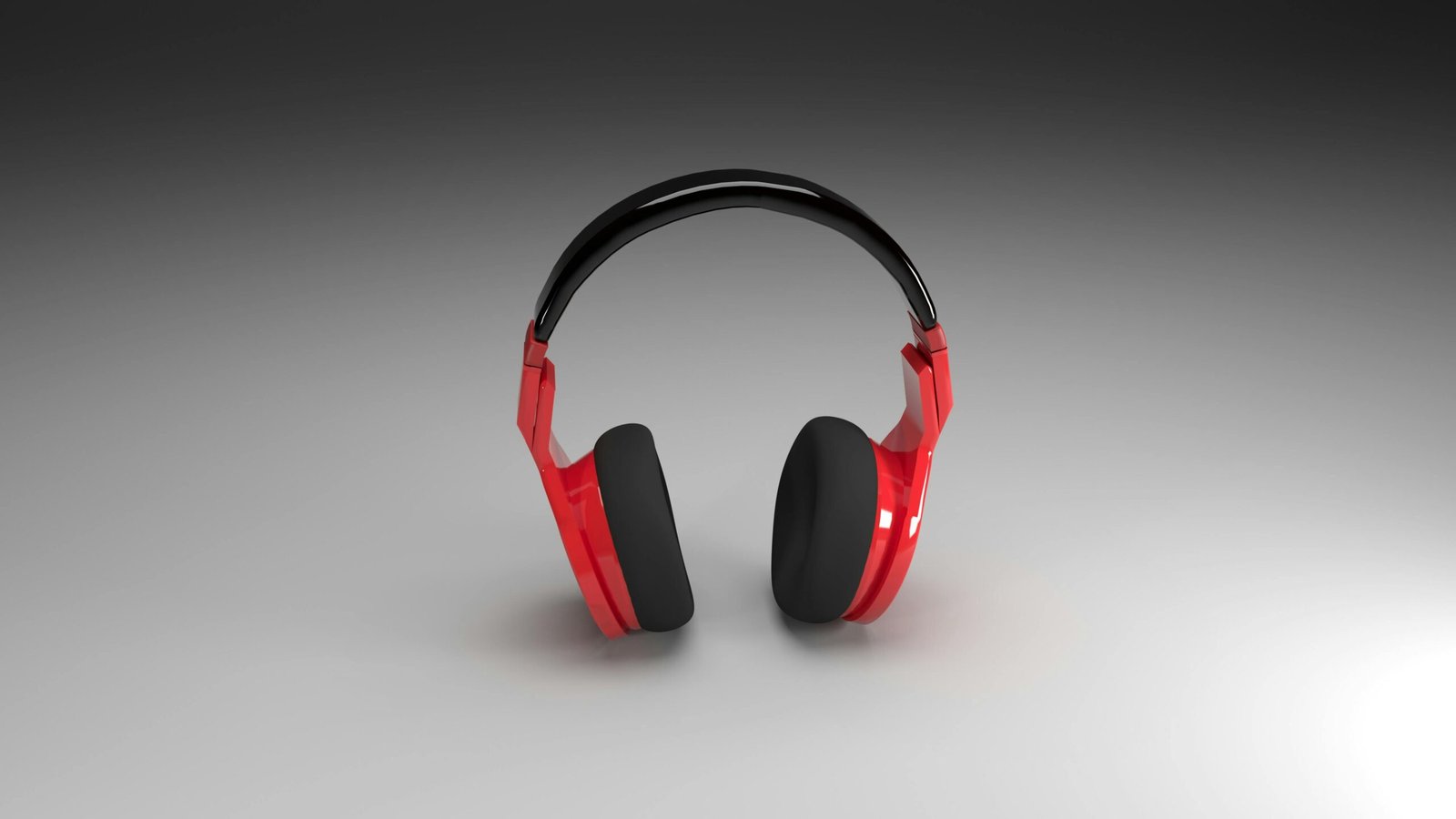 Vibrant red headphones isolated on a smooth gray gradient background, perfect for music and technology themes.