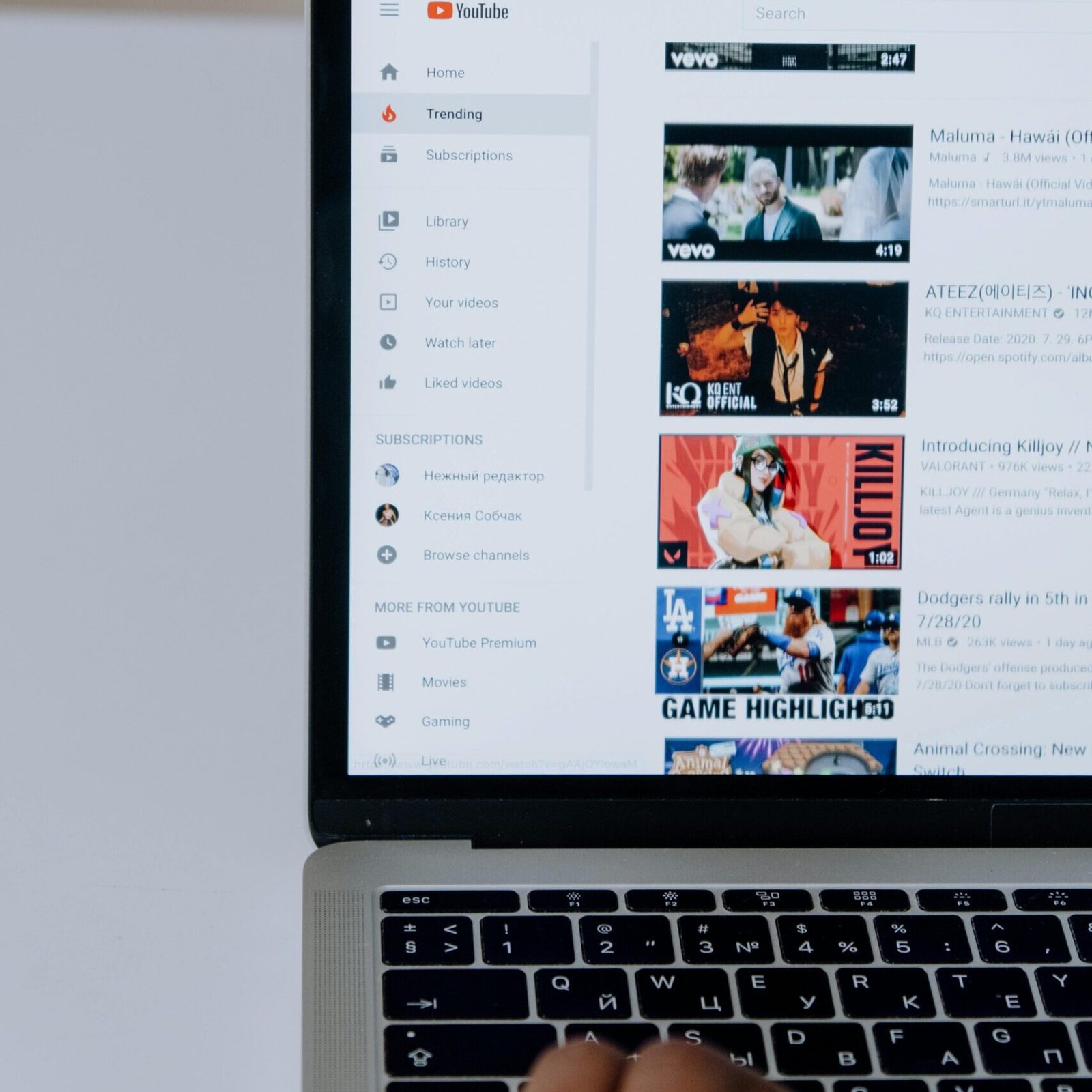 Person browsing YouTube videos on a laptop, showcasing modern technology and online content.